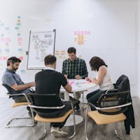 A group of people sitting down in an office working as a team